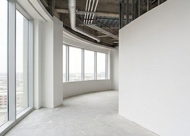 Finished white walls along a curved window wall in a commercial office