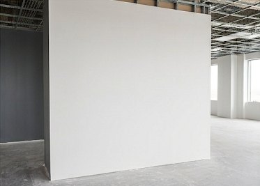Finished drywall partition with a dark accent wall in an office suite
