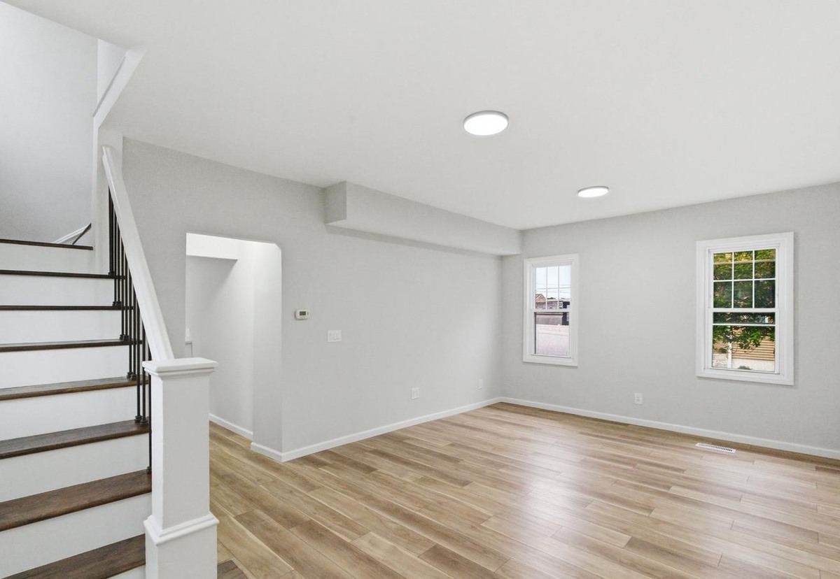 Stair hall and living area with new flooring and paint after a make-ready